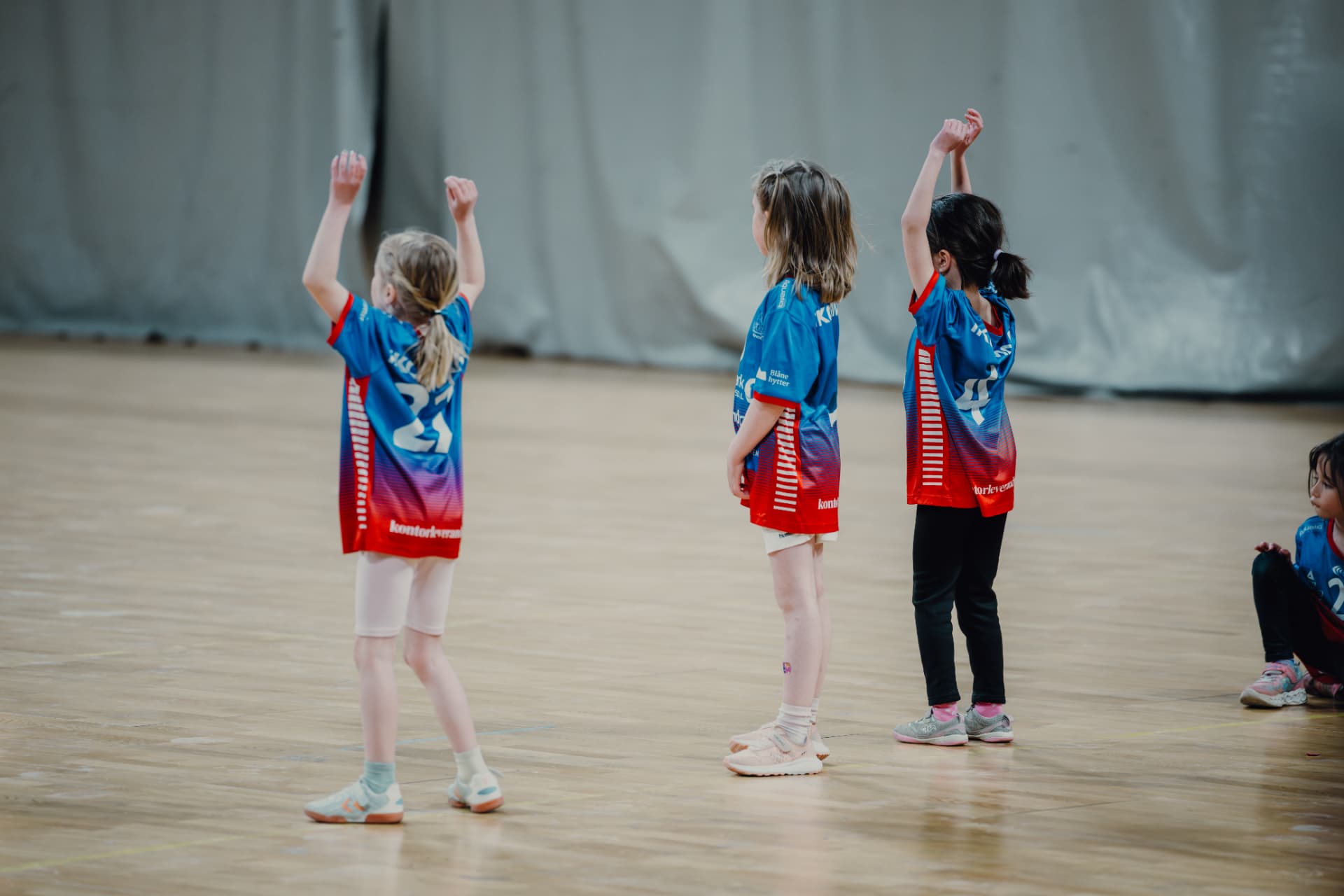 Barn som spiller håndball i gymsal